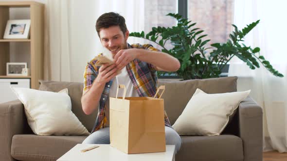 Man Unpacking and Eating Takeaway Food at Home