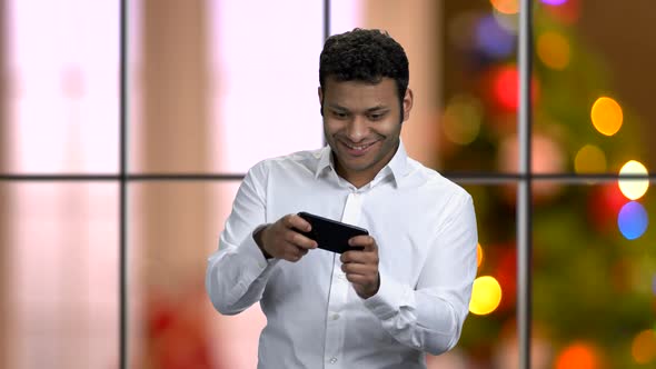 Energetic Businessman Playing Game on Smartphone