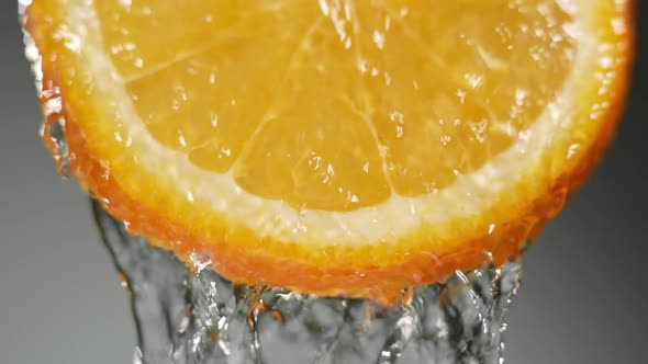 Water Splashing on Fresh Orange in Slow Motion