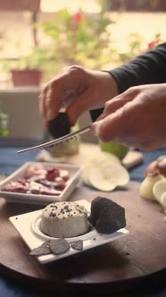 Crop cook grating truffle above cheese at home