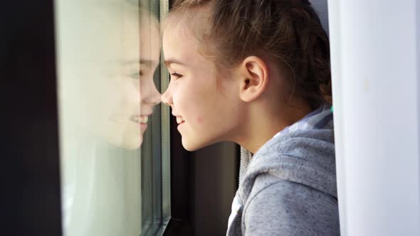 Happy Teen Girl Look Out of Window Outside