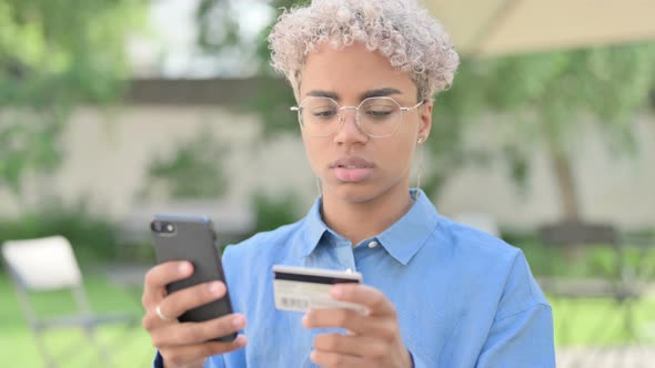 Portrait of Young African Woman Making Online Payment on Smartphone