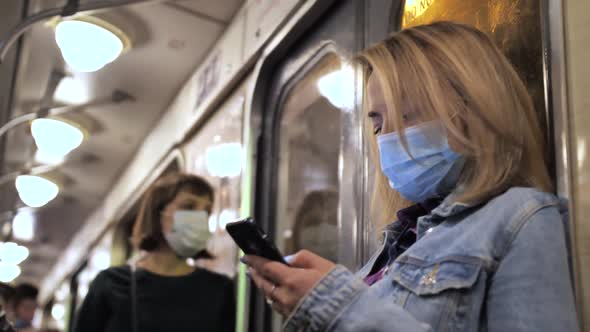 Masked Woman Using Cellphone in Underground Metro