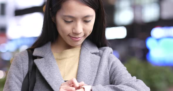 Businesswoman using smart watch in Hong Kong at night