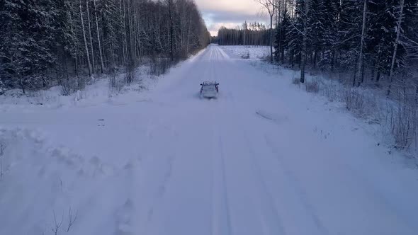 Aerial view of a car driving in the snowy forest in Estonia