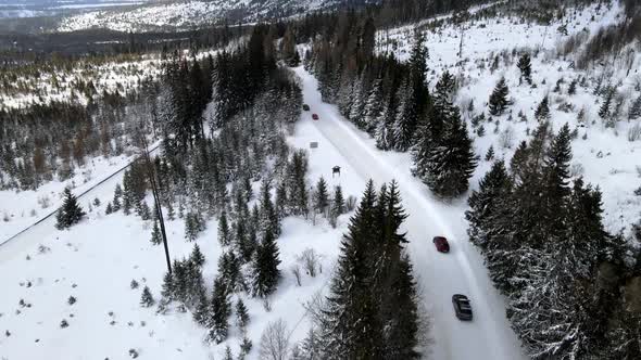 Aerial View of Car Moving By Snowed Road in Mountains