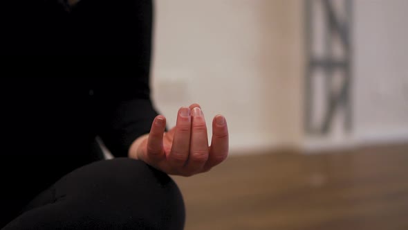 Closeup shot of female yoga instructor's hand in her fitness studio. Meditation and relaxation conce