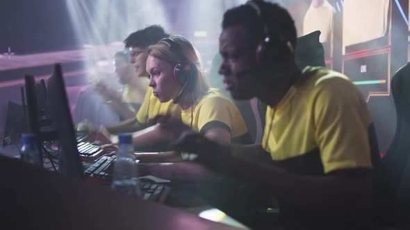 Young Woman Celebrating Victory in Video Game with Teammates