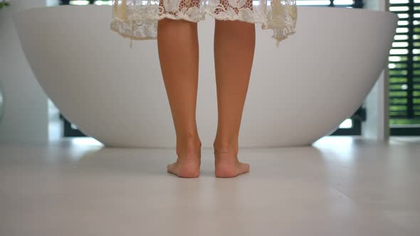 Back Shot of a Woman Stepping Into the Bath