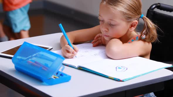 Disabled schoolgirl studying in classroom