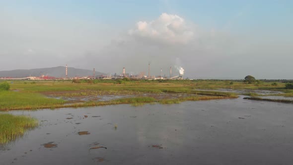 Drone dolly forward drone shot over Waterlogged Indian rice paddy & fish farming fields towards indu