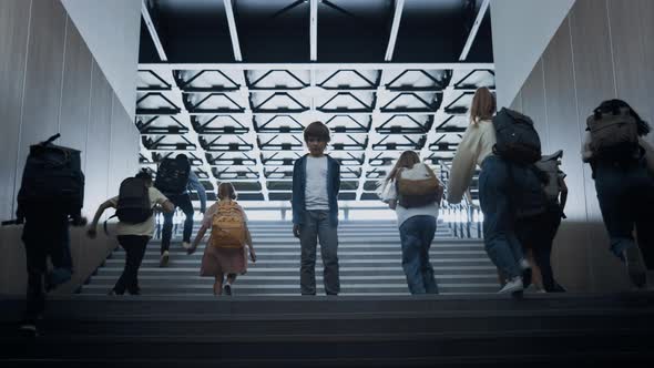 Students Running Upstairs Ignoring Upset Boy on Way