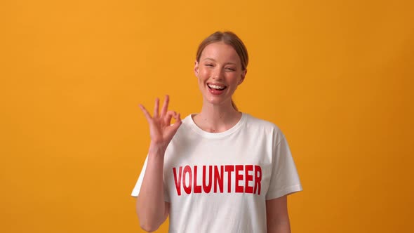 Smiling woman volunteer showing okay sign at the camera