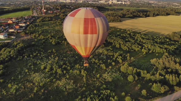 Large Hot Air Balloon Flies Over Green Forest Near Town