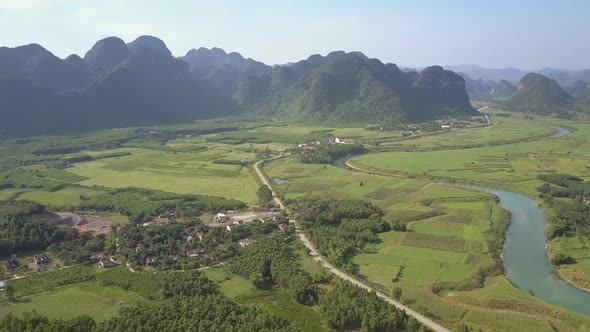 Town Among Fields at Way and River Against Hills Aerial View