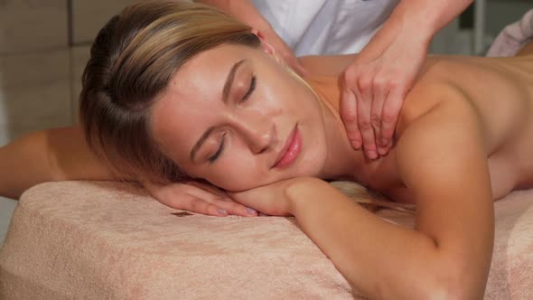 Young Happy Woman Receiving Relaxing Back Massage at the Salon