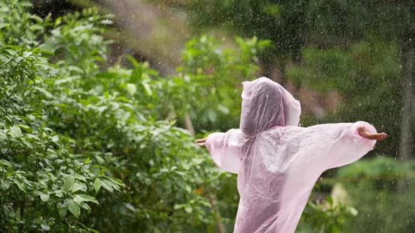 Happy girl wears raincoat and spread arms