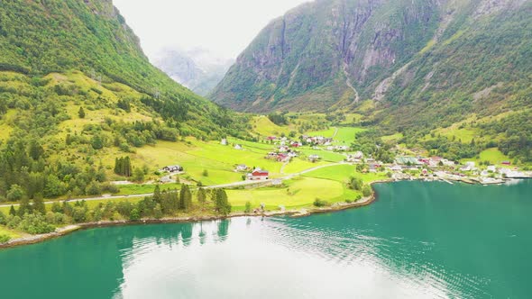 Beautiful town between mountains on the shore of a stunning Lake - Aerial footage