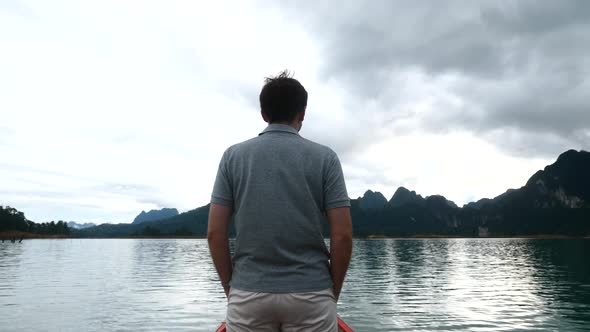 Tourist Man Standing on the Boat and Enjoying Beautiful View on Morning Lake