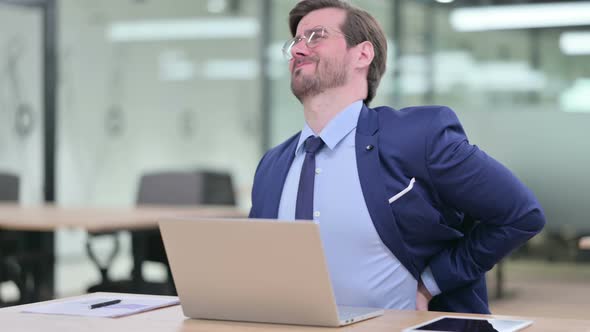 Hardworking Young Businessman with Laptop Having Back Pain 