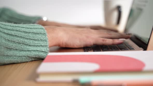 Close Up of Female Hands Typing on Modern Laptop Making Notes