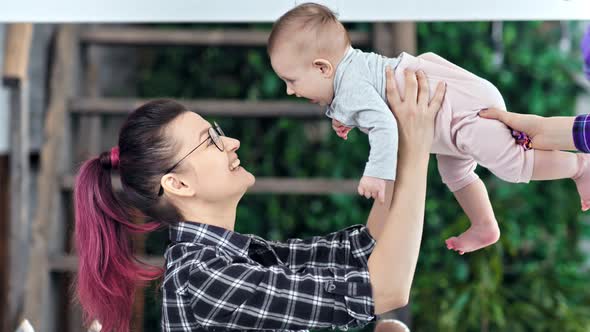 Young Hipster Mother Feeling Pleasure Playing with Her Little Cute Daughter Medium Closeup