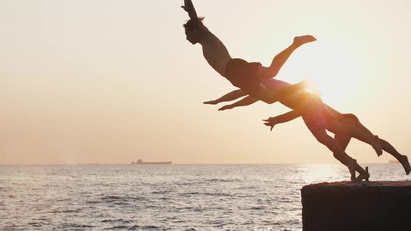 Group of Young Friends Jumping From a Pier Into the Sea Super Slow Motion