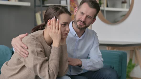 Man Trying to Comfort Upset Female Partner on Sofa