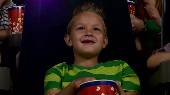 Happy Boy with Popcorn Watching a Movie. Close Up