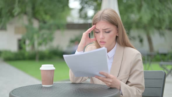 Young Businesswoman Having Loss While Reading Documents