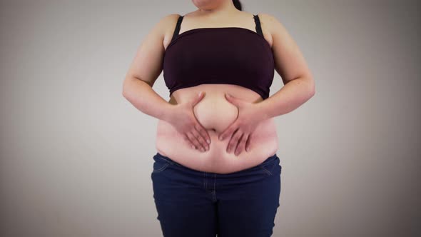 Unrecognizable Caucasian Woman Shaking Fat on Tummy. Obese Young Woman Touching Belly. Overweight