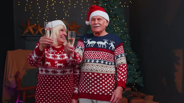 Joyful Senior Family Couple Celebrating Christmas at Home Clinking Glasses and Drinking Champagne