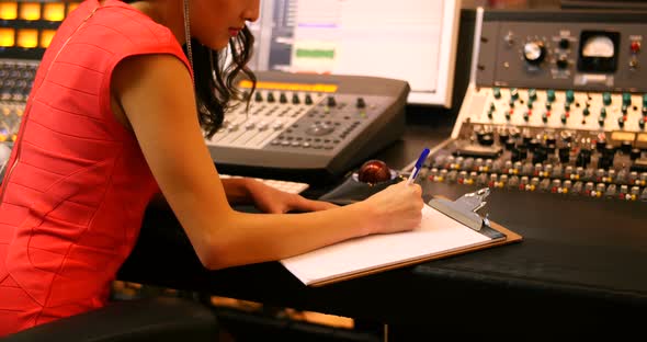 Female audio engineers writing on clipboard