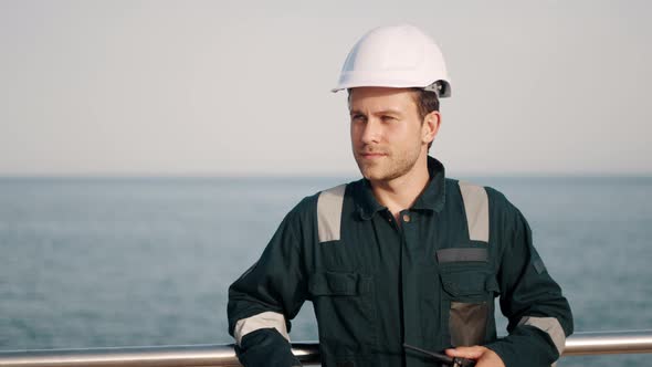 Ship Port Worker with Walkietalkie Radio and Clipboard in Hands During Cargo Logistics Control