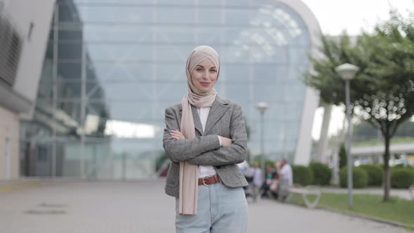 Muslim Woman Standing on the Background of Modern Building with Arms Crossed Showing Okay Gesture