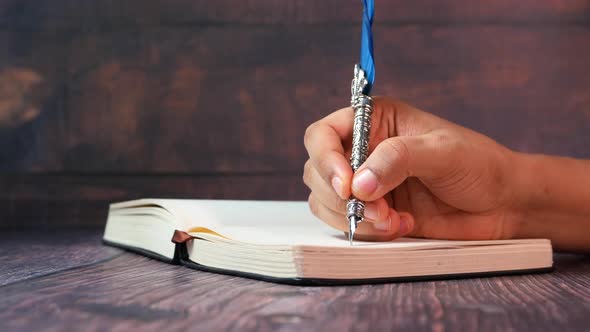 Close Up of Women Hand Writing with Fountain Pen on a Dairy 