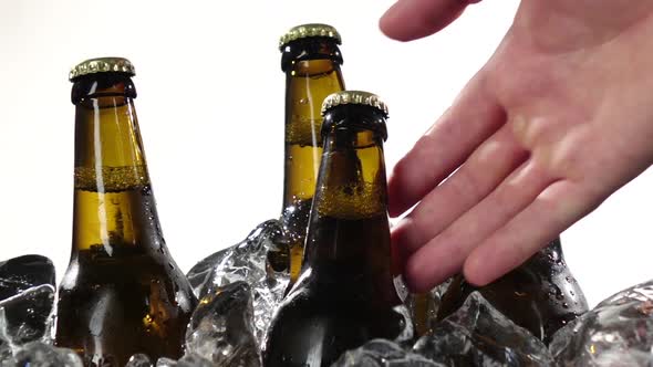 Guy Takes a Bottle of Cold Beer. White Background . Close Up. Slow Motion