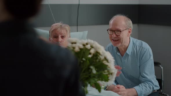 Close Up of Family Surprising Ill Grandma in Hospital Ward