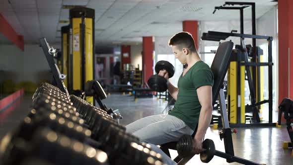 Handsome Young Man Doing Dumbbell Exercises in Gym, Building Muscular Body