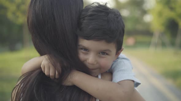 Closeup Cute Happy Middle Eastern Boy Hugging Unrecognizable Young Woman Smiling Camera