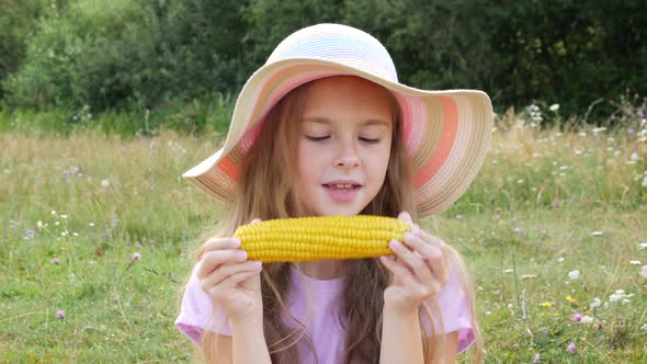 A Charming Girl Eats Fragrant Corn Wearing Summer Hat