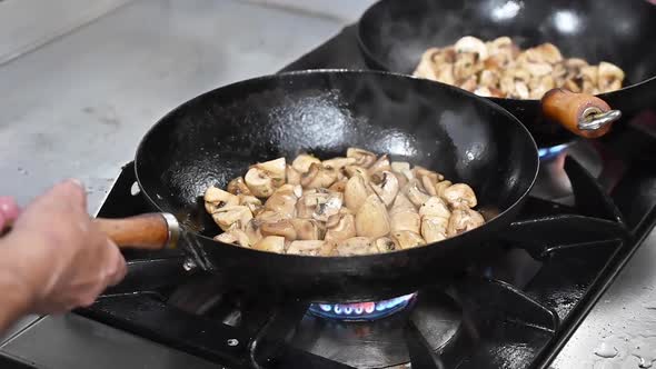 Chef Cooking Mushrooms in Frying Pan on Burning Fire Slow Motion. 