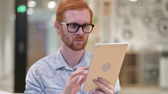 Portrait of Attractive Casual Redhead Man Using Digital Tablet