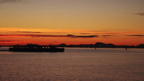 Cargo Ship Motorboat with People Cross Dark Sea at Sunset