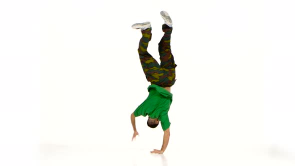 Talanted Young Dancer Man in Green Shirt Starts Dancing Breakdance on White
