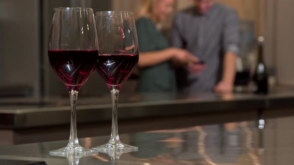 Wine Glasses on the Table Couple Using Smartphone Together Background