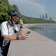 Cyclist in a Helmet and Sports Glasses, Watching an Application on His Smartphone. - VideoHive Item for Sale
