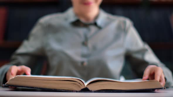 Closeup Unrecognizable Woman Open Vintage Paper Book on Library Desk Education Science Information alt