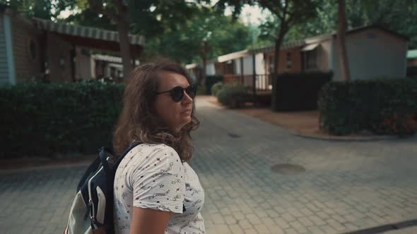 Brunette Woman with Sunglasses Is Admiring Architecture and Nature of Small City