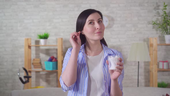 Positive Young Woman Uses Ear Cleaning Hygienic Cotton Stick